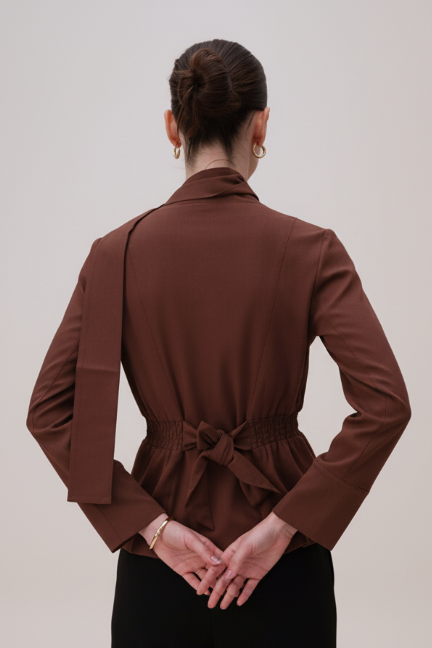 Brown blazer worn by a person on a plain background