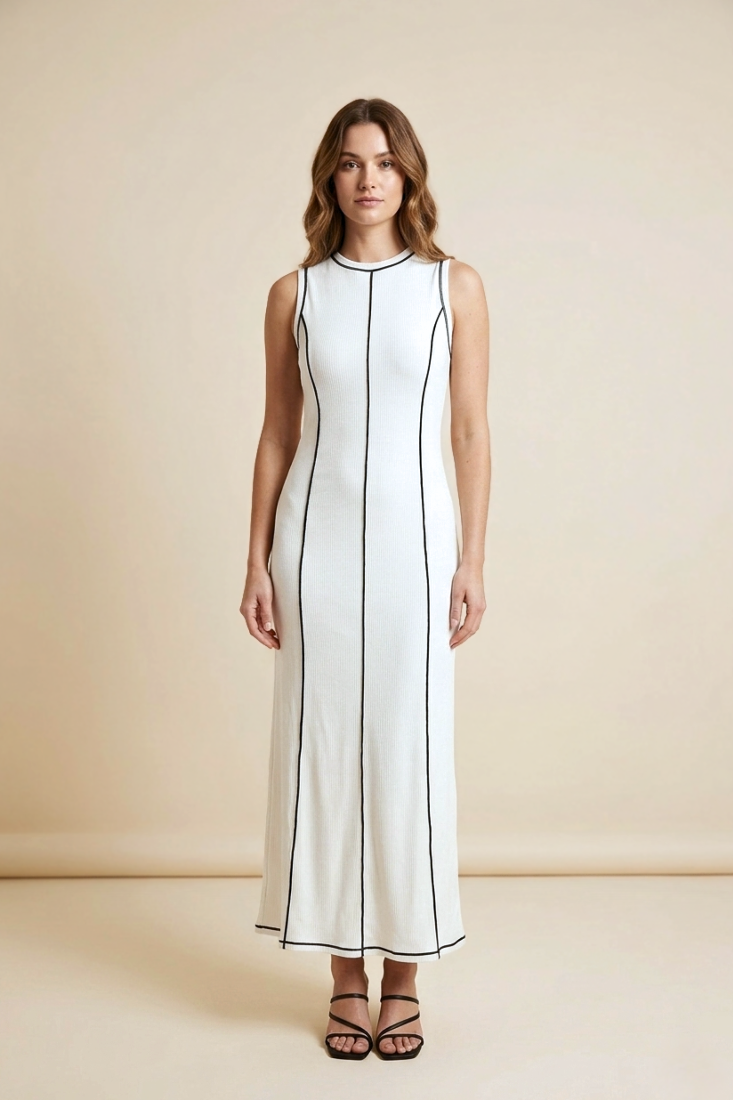 Woman wearing a white dress with black trim on a beige background