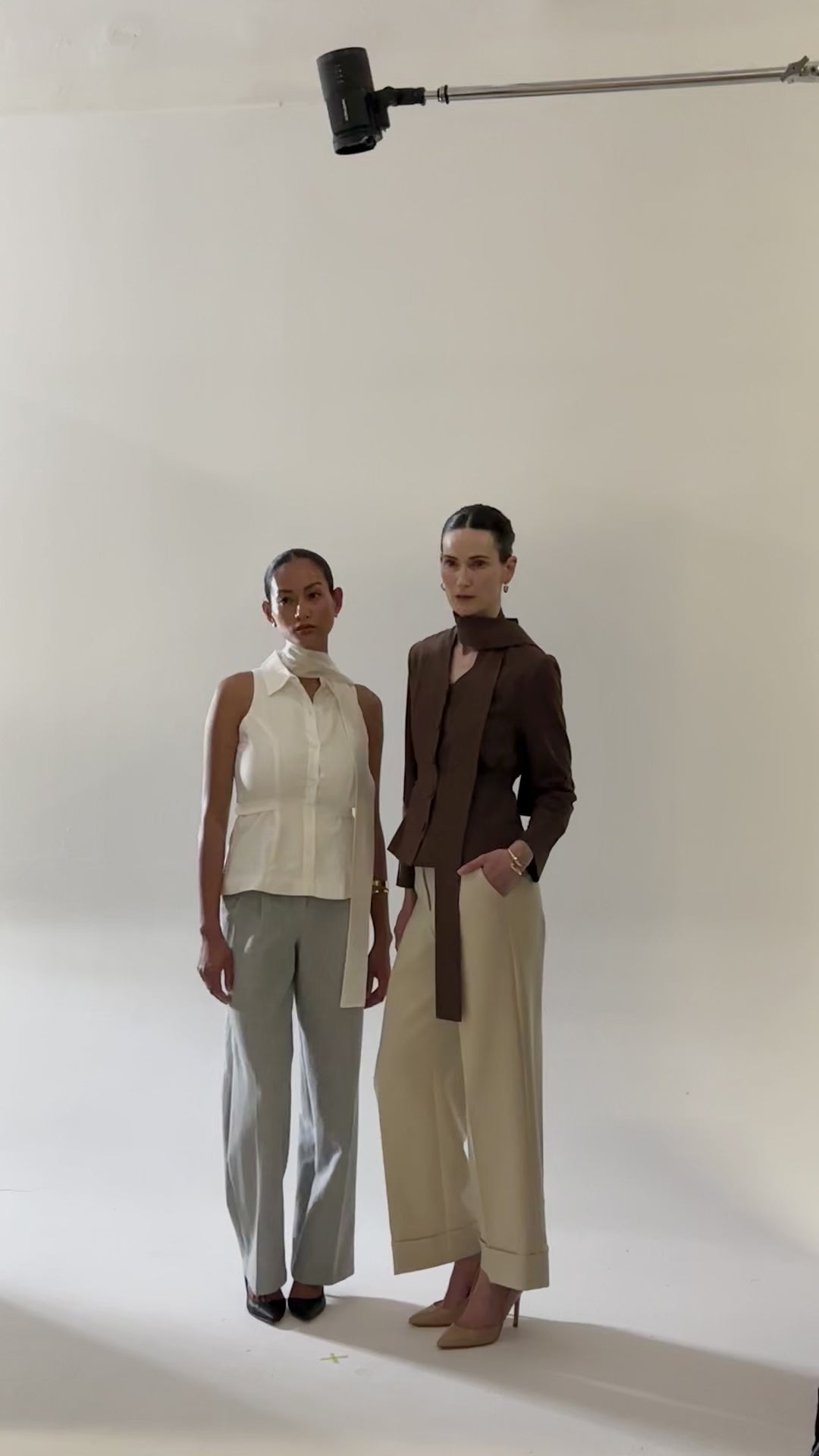 Load video: One model is wearing white shirt with scarf and other one is wearing brown blazer shirt with scarf.